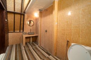 a bathroom with a tub and a sink and a mirror at Tricky Trees Sunset Bungalows in Gili Air +39 photos