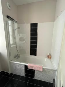 a bathroom with a tub with a glass shower at sainte anne petite venise colmar in Colmar