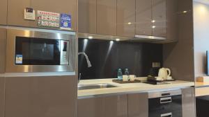 una cocina con fregadero y microondas en 诺盟国际公寓北京路捷登都会店, en Guangzhou 21 fotos más