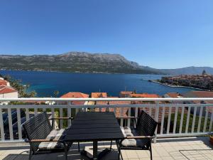 une table et des chaises sur un balcon avec vue sur l'eau dans l'établissement Apartment Sea Dance, Korcula town, à Korčula