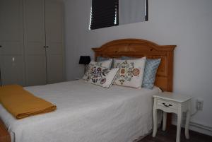 a bedroom with a bed with pillows and a table at The Ranch House Bragadiru in Bragadiru