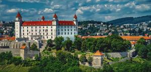 a large white castle with red roofs on a hill at Luxury City Loft Modern and Elegant in Bratislava