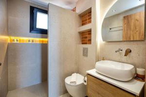 a bathroom with a sink and a toilet and a mirror at Emmeli's de lux apartments 1 in Skala Marion +20 photos