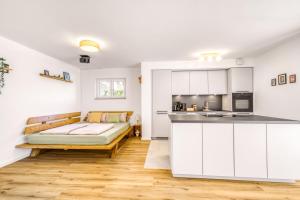 a kitchen with white cabinets and a couch in a room at Edel & Exklusiv - Heimkino, Kochinsel, Parkplatz, XXL-Betten & Mehr in Scheyern