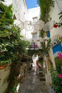 an alley with flowers and plants in a building at Casa Giglio in Ostuni