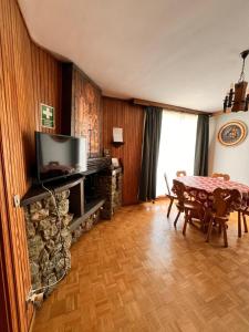 a living room with a table and a television at Una Finestra sul Cervino in Breuil-Cervinia