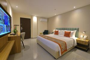 a bedroom with a large bed and a flat screen tv at Hotel Grand Continent Premiere, Banjara Hills, Hyderabad in Hyderabad +33 photos