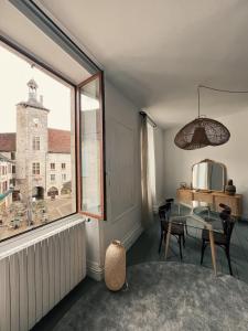 a dining room with a table and a large window at Le Haut des Halles in Martel