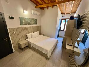 a small bedroom with a bed and a television at Ados Hotel in Cesme