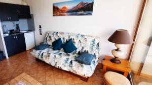 a living room with a couch and a table with a lamp at La Monarde in Gérardmer
