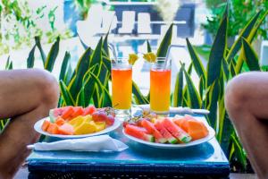 two plates of fruit and two glasses of orange juice at Lourdes Inn in Negombo