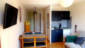 a kitchen with a table and chairs in a room at La Monarde in Gérardmer
