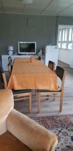 a room with a table with chairs and a tv at Aliise Garden Guesthause in Pärnu