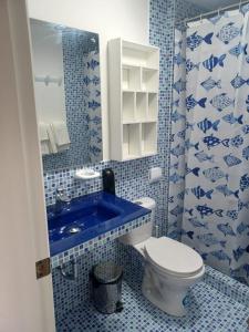 a blue and white bathroom with a toilet and a sink at Casa Sharlen in Hacienda El Tambo +28 photos