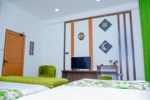 a room with two beds and a television at Lourdes Inn in Negombo