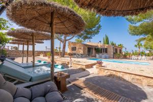 an outdoor patio with umbrellas and a swimming pool at Banc Doli in Manacor