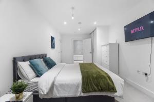 a white bedroom with a bed and a couch at Luxury 2 BR Riverview Ensuite Flat in Greenwich Near O2&Excel in London