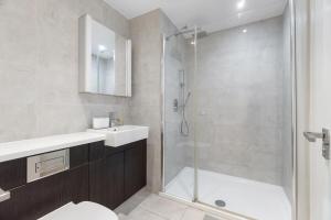 a bathroom with a shower and a toilet and a sink at Luxury 2 BR Riverview Ensuite Flat in Greenwich Near O2&Excel in London +11 photos
