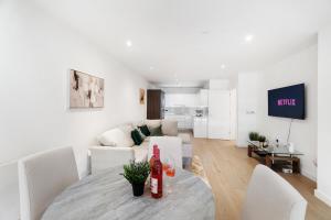 a white living room with a table and a couch at Luxury 2 BR Riverview Ensuite Flat in Greenwich Near O2&Excel in London