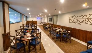 a restaurant with tables and chairs in a room at Legend Hotel Kachura in Ponedas