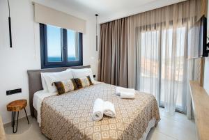 a hotel room with a bed with towels on it at Emmeli's de lux apartments in Skala Marion
