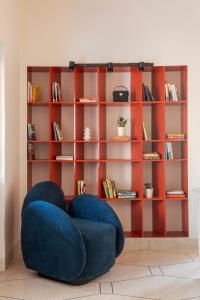 a room with a blue chair and a book shelf at Namli Haus - A Boutique Luxury Stay Jaipur in Jaipur