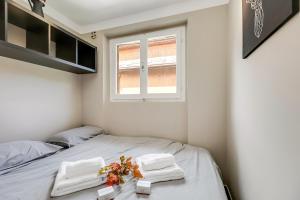 a bedroom with a bed with towels and a window at Boutique Apartment Limone Ski In Ski Out - Happy Rentals in Limone Piemonte