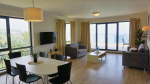 a living room with a table and chairs at Апартаменти Бяла Бийч - Apartments Byala Beach in Byala