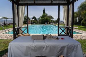 a bed in a gazebo next to a swimming pool at Podere Val D'Orcia - Tuscany Equestrian in Sarteano