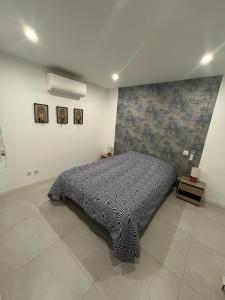 a bedroom with a bed with a blanket on it at Le provencal in La Roque-dʼAnthéron