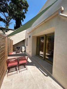 a patio with a table and chairs next to a building at Le provencal in La Roque-dʼAnthéron
