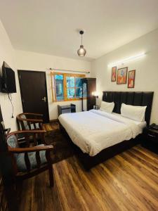 a bedroom with a large white bed and a chair at The Boho Woods Resort in Nainital +29 photos