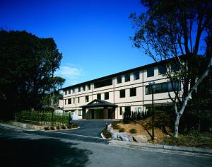 a large white building on the side of a street at Red 28 in Ito