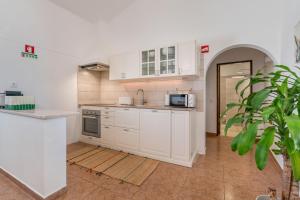 a kitchen with white cabinets and a counter top at Casa Esmeralda - Vineyard View in Porches +7 photos