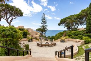 a patio with a table and chairs and the ocean at Vilalara Grand Hotel Algarve in Armação de Pêra