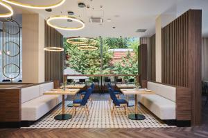 a restaurant with tables and chairs and a large window at voco Katowice by IHG in Katowice