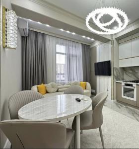 a living room with a table and a couch at Квартира Оксижен в жк Парк Авеню in Bishkek +4 photos