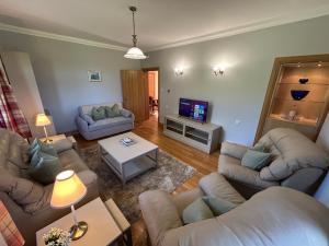 a living room with couches and a flat screen tv at Shawsmill, outside Hurlford in Hurlford