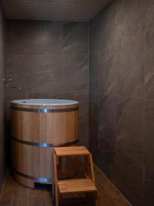a bathroom with a wooden tub and a wooden stool at APANÓWKA domki z balią jacuzzi sauna in Trzebiechowo