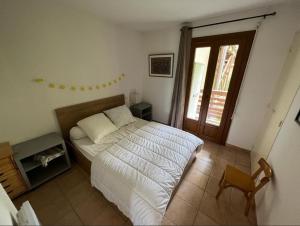 a bedroom with a bed and a chair and a window at Appartement 6 couchages proche des pistes et commerces in Les Angles