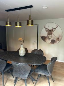 奥门Wildthout Boshuisjes en Appartementen的餐桌、椅子和墙上的鹿