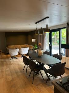 奥门Wildthout Boshuisjes en Appartementen的带桌椅和沙发的客厅