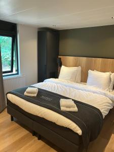 奥门Wildthout Boshuisjes en Appartementen的一间卧室，有一张大床，床上有两条毛巾