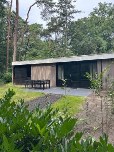 奥门Wildthout Boshuisjes en Appartementen的一间前面有一张野餐桌的房子 更多26张照片