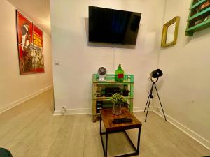 a room with a television on a wall with a table at LE Globe in Paris