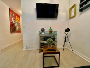a living room with a television on a wall at LE Globe in Paris