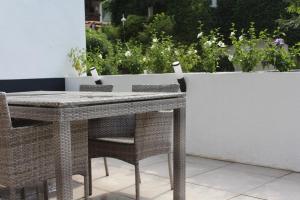 a wicker table and chairs on a patio at Ferienwohnung Jungpfalzstieg in Rinnthal