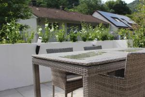 a wicker table and chairs on a patio at Ferienwohnung Jungpfalzstieg in Rinnthal