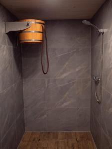 a bathroom with a shower and a shower head at APANÓWKA domki z balią jacuzzi sauna in Trzebiechowo +15 photos