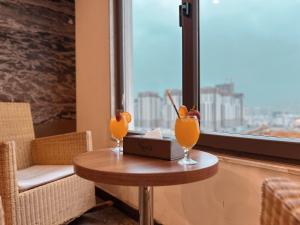 ein Tisch mit zwei Gläsern darauf und einem Fenster in der Unterkunft Nova Sky Hotel in Erbil